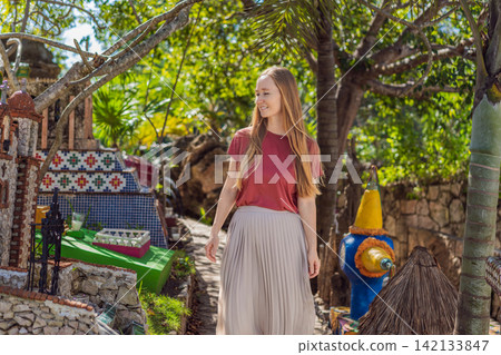 Woman tourist visiting traditional Mexican cemetery during Day of the Dead, walking among colorful graves and folk art in Mexico, cultural travel concept 142133847
