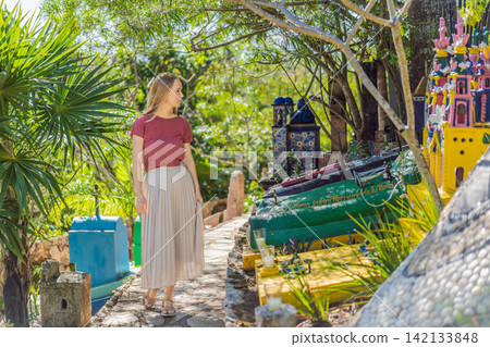 Woman tourist visiting traditional Mexican cemetery during Day of the Dead, walking among colorful graves and folk art in Mexico, cultural travel concept 142133848