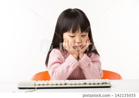 Asian Little Girl Exploring Computer Keyboard with Curiosity Asian Little Girl Exploring Computer Keyboard with Curiosity 142135035