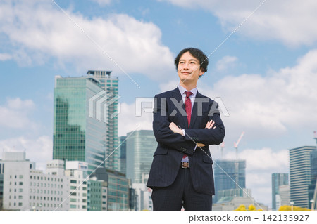 一位商人雙手交叉放在胸前,站在辦公區。 一位商人雙手交叉放在胸前,站在辦公區。 142135927