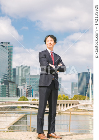 一位商人雙手交叉放在胸前,站在辦公區。 一位商人雙手交叉放在胸前,站在辦公區。 142135929