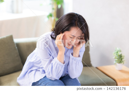 身體不好,頭痛,中年婦女抱頭 身體不好,頭痛,中年婦女抱頭 142136176