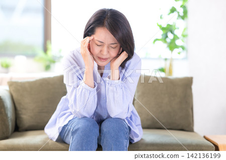 身體不好,頭痛,中年婦女抱頭 身體不好,頭痛,中年婦女抱頭 142136199