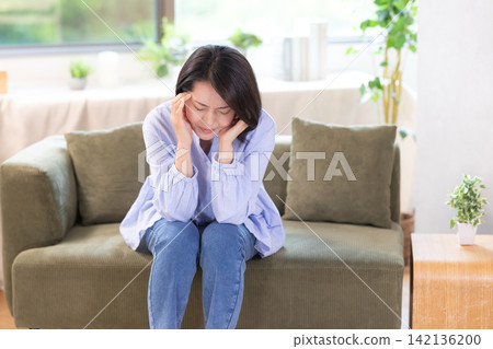 身體不好,頭痛,中年婦女抱頭 身體不好,頭痛,中年婦女抱頭 142136200