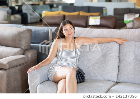 Female customer choosing comfortable lounge furniture in store Female customer choosing comfortable lounge furniture in store 142137356
