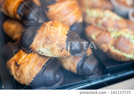 Variety of chocolate croissants in window of coffee shop or store Variety of chocolate croissants in window of coffee shop or store 142137575