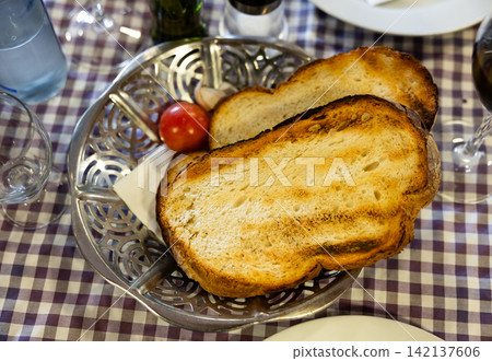 Pan con tomate - grilled bread topped with mixture of grated tomatoes with salt and olive oil. Popular Catalan wine tapas Pan con tomate - grilled bread topped with mixture of grated tomatoes with salt and olive oil. Popular Catalan wine tapas 142137606