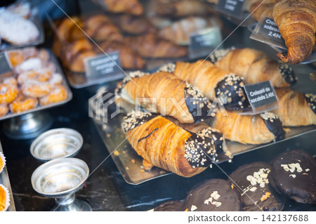 Chocolate croissants with a tender and juicy filling. Baked goods are displayed in window 142137688