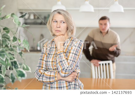 Man screams during family quarrel with woman in domestic kitchen Man screams during family quarrel with woman in domestic kitchen 142137693