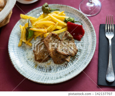 Fried pork with roasted potatoes and grilled peppers Fried pork with roasted potatoes and grilled peppers 142137707
