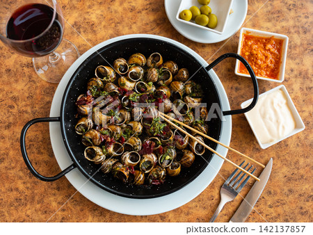 Snails cooked in shells with ham garlic and parsley Snails cooked in shells with ham garlic and parsley 142137857