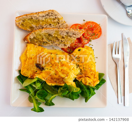 Omelet with bread and salad on a plate 142137908