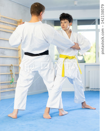 Teenage boy applying judo techniques on middle-aged trainer during sports classes Teenage boy applying judo techniques on middle-aged trainer during sports classes 142138079