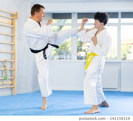 Man and teenage boy training karate fight Man and teenage boy training karate fight 142138119