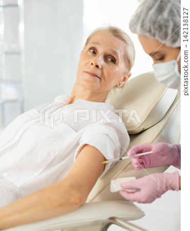Elderly female patient receiving intramuscular injection in medical office Elderly female patient receiving intramuscular injection in medical office 142138127