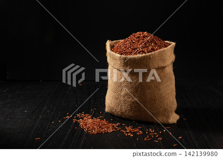 raw Whole Grain Red Cargo Rice in Burlap Sack raw Whole Grain Red Cargo Rice in Burlap Sack 142139980