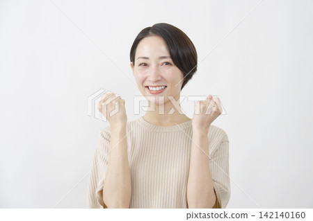 Woman, middle-aged, making a victory pose, against a white background. 142140160