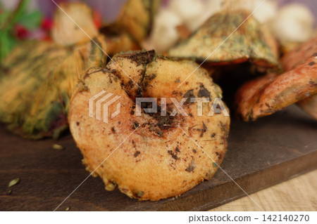 Mushrooms placed on a wooden surface in a kitchen Mushrooms placed on a wooden surface in a kitchen 142140270
