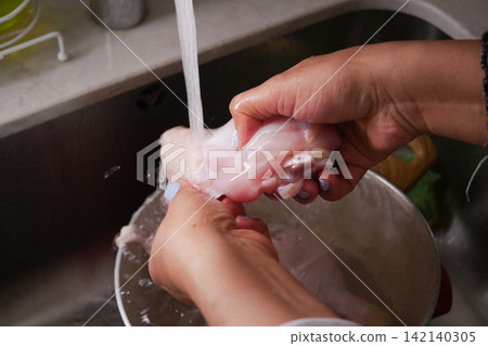 Cleaning food in the kitchen sink at home 142140305