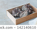 Taro harvested in wooden boxes with the soil still attached. 142140610