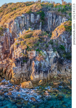 Aerial view of the rugged rocky headland at Diamond Head surrounded by clear turquoise ocean water, showcasing the natural coastal landscape and pristine marine environment on the Mid North Coast Aerial view of the rugged rocky headland at Diamond Head surrounded by clear turquoise ocean water, showcasing the natural coastal landscape and pristine marine environment on the Mid North Coast 142141113