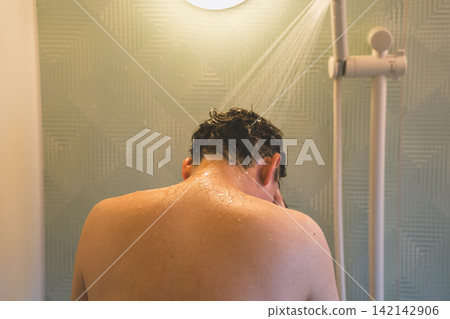 一位40歲男子洗澡時:低頭淋浴。 一位40歲男子洗澡時:低頭淋浴。 142142906