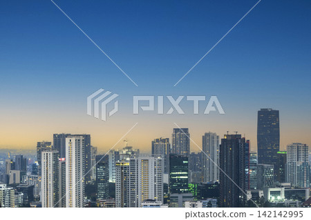 Scenic view of a modern Jakarta metropolis skyline featuring skyscrapers under a clear blue and gold twilight sky at dusk. Cityscapes background Scenic view of a modern Jakarta metropolis skyline featuring skyscrapers under a clear blue and gold twilight sky at dusk. Cityscapes background 142142995