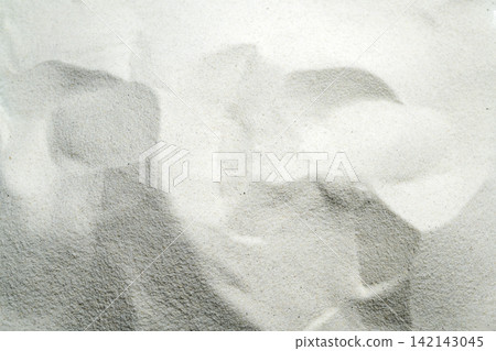 An overhead view of fine white sand showing natural wavy ripple patterns, creating a clean, minimalist texture. Summer, natural or texture background 142143045