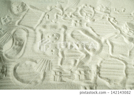 Overhead view of patterns, shapes, and textures imprinted in fine white play sand. Summer, natural or texture background Overhead view of patterns, shapes, and textures imprinted in fine white play sand. Summer, natural or texture background 142143082