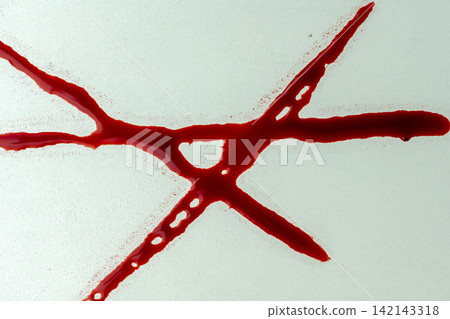 Red liquid resembling blood smeared in an abstract shape on a frosted glass surface, ideal for horror, crime, or medical concepts. Halloween concept Red liquid resembling blood smeared in an abstract shape on a frosted glass surface, ideal for horror, crime, or medical concepts. Halloween concept 142143318