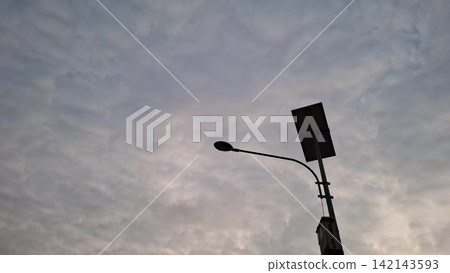 Solar Powered Street Lamp Against Cloudy Sky 142143593