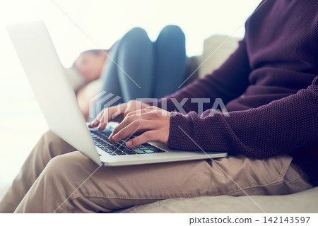 Hands, man and laptop on sofa for remote work in morning with woman sleeping in home living room. People, computer and typing for report, article or creativity in freelance writing career on couch Hands, man and laptop on sofa for remote work in morning with woman sleeping in home living room. People, computer and typing for report, article or creativity in freelance writing career on couch 142143597