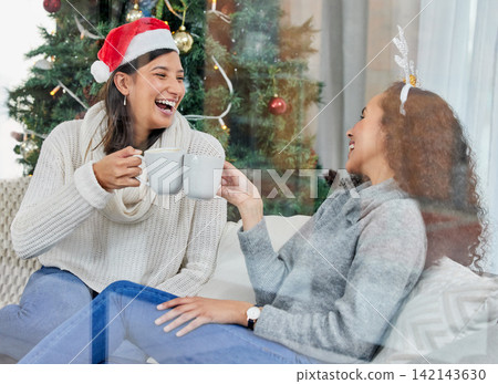 Happy woman, friends and Christmas with coffee on sofa at home for celebration or festive season. Female person or people laughing with smile for conversation, funny joke or drink on December holiday Happy woman, friends and Christmas with coffee on sofa at home for celebration or festive season. Female person or people laughing with smile for conversation, funny joke or drink on December holiday 142143630