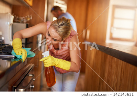 Woman, wipe and spray surface of stove in home, maid and disinfection for hygiene or housekeeping. Female person, chemical and fabric or cloth, bacteria and gloves to protect from germs or dirt 142143631
