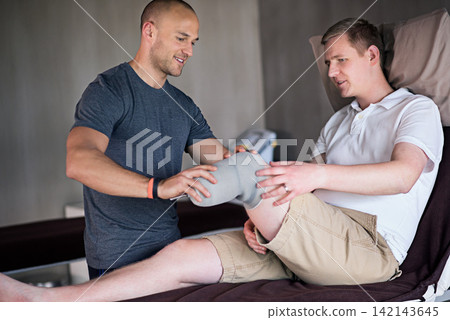 Amputee, medical and physiotherapist with man for rehabilitation in clinic for physical therapy. Healthcare, professional and patient with disability for consultation, help and check in health center Amputee, medical and physiotherapist with man for rehabilitation in clinic for physical therapy. Healthcare, professional and patient with disability for consultation, help and check in health center 142143645