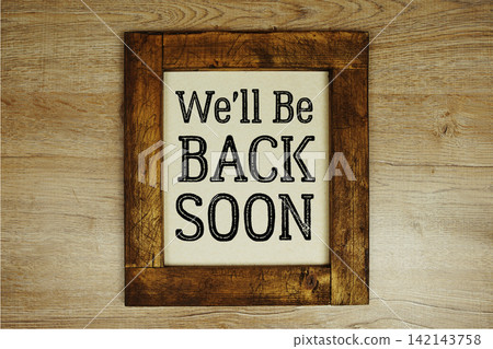 We'll Be Back Soon text written on wooden frame top view on wooden background We'll Be Back Soon text written on wooden frame top view on wooden background 142143758