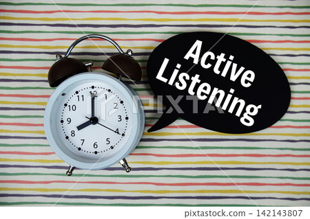 Active Listening text on speech bubble with alarm clock on colorful stripes background Active Listening text on speech bubble with alarm clock on colorful stripes background 142143807