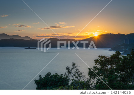 Sunburst sunset over Sun Moon Lake in Taiwan Sunburst sunset over Sun Moon Lake in Taiwan 142144026