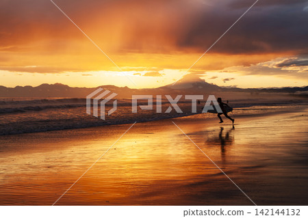 孩子們在湘南久沼海灘迎著落日的天空和大海衝浪。 142144132
