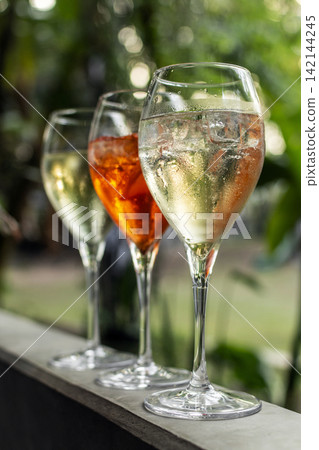 different iced spritzer wine cocktail drinks at outdoor garden bar party on sunny day different iced spritzer wine cocktail drinks at outdoor garden bar party on sunny day 142144245