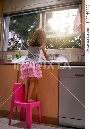 Girl, chair and washing dishes in kitchen, chore and helping to clean for hygiene or disinfect dirt. Female person, back and water splash or bubbles for bacteria prevention, wet and care for germs Girl, chair and washing dishes in kitchen, chore and helping to clean for hygiene or disinfect dirt. Female person, back and water splash or bubbles for bacteria prevention, wet and care for germs 142144302