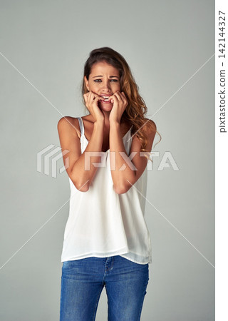 Woman, portrait and biting nails or nervous in studio with anxiety disorder, mistake or worried. Female person, face and stressed fear on grey background or scared conflict, mockup space or phobia Woman, portrait and biting nails or nervous in studio with anxiety disorder, mistake or worried. Female person, face and stressed fear on grey background or scared conflict, mockup space or phobia 142144327