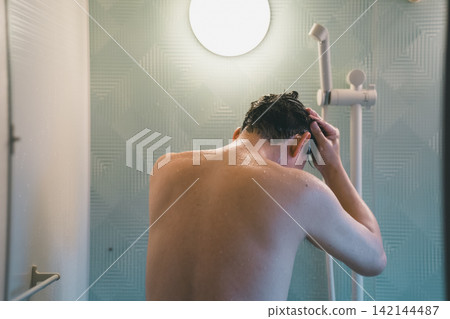 A man's shower time, rinsing his hair. A man's shower time, rinsing his hair. 142144487