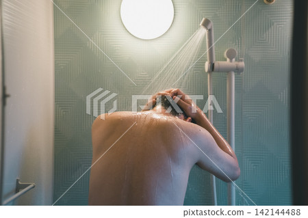 A man's shower time, rinsing his hair in the shower. A man's shower time, rinsing his hair in the shower. 142144488
