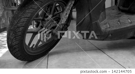Black and White Motorcycle Front Wheel and Scooter Detail Black and White Motorcycle Front Wheel and Scooter Detail 142144705