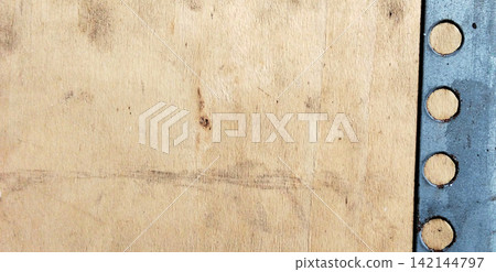Light colored plywood panel with perforated metal frame on the right side. Light colored plywood panel with perforated metal frame on the right side. 142144797