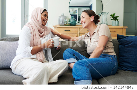 Drinking coffee, smile and friends in home for talking, support or girls relax on sofa. Tea, happy women and conversation in living room, laugh or communication of interracial people bonding together Drinking coffee, smile and friends in home for talking, support or girls relax on sofa. Tea, happy women and conversation in living room, laugh or communication of interracial people bonding together 142144842