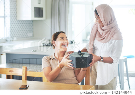 Kitchen, women and friends, gift and smile for box, thank you and birthday in house, ribbon and care. Home, hijab and Muslim female person with present, package and kindness and happy with gratitude Kitchen, women and friends, gift and smile for box, thank you and birthday in house, ribbon and care. Home, hijab and Muslim female person with present, package and kindness and happy with gratitude 142144944