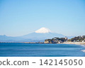 A breathtaking view of the beautiful blue sky and snow-capped Mount Fuji from the coast of Kamakura. 142145050