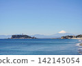 Enoshima Island and snow-capped Mount Fuji as seen across the blue sea. 142145054